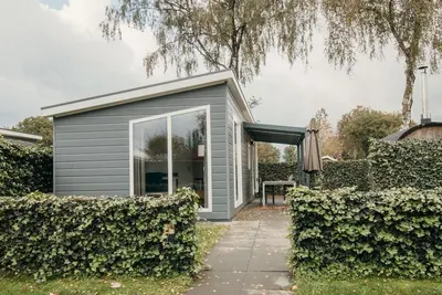 Image de Experience the ultimate getaway in the Veluwelodge Xl with private sauna for 5 people at Recreatiepark De Boshoek, nestled in the nature of the Veluwe.