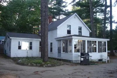 Image de Classic pine paneled Maine cottage with large sandy beach on Sebago Lake.
