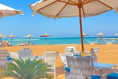 Image de G. 3. 11 Red Seafront apartment. Restaurant on beach, lounge chairs, umbrellas