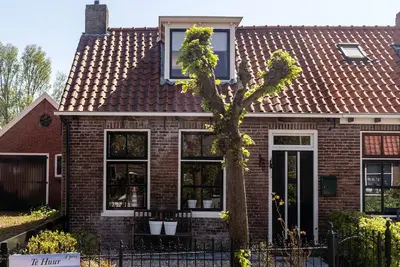 Image de Jolies maisonnettes typiques des Wadden, situées côte à côte, à proximité de la mer des Wadden.