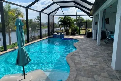 Image de Intersecting canal home with dock, mineral pool, sauna, hot tub, outdoor kitchen