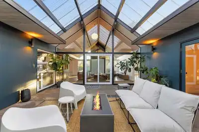Image de This Robert Rummer masterpiece celebrates mid-century design and A. Quincy Jones’ iconic “double gable. ” Soak in natural light from the atrium, relax under vaulted ceilings, and retreat to your private hot tub where style and serenity meet.