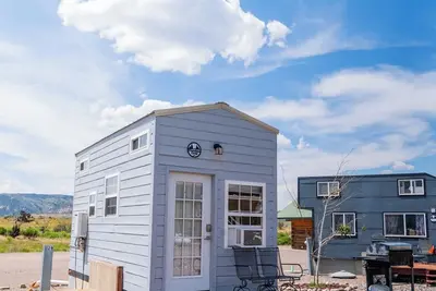 Image de Adorable Tiny Home with two lofts. Both are accessible by ladder. One has a Queen mattress and the other has a Twin mattress. Home also contains a folding Full futon on main level. Sleeps: 4