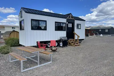Image de Our newest and one of our largest tiny homes contains a queen bed on the main level and two queen lofted beds. Sleeps: 6
