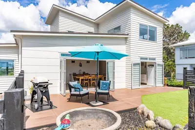 Image de All Decked Out - Modern holiday home with multiple decks including a covered outdoor entertaining space with open fireplace and plastic blinds. Close to shops, cafe, golf course, estuary and Mangawhai Activity Zone. Pet Friendly.