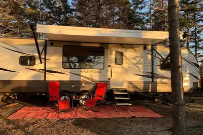 Image de Modern Rv camper with all the perks \nNestled in tree at lake edge