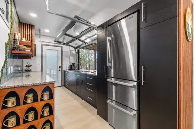 Image de Epic Rrg Stay | Rooftop deck + slide | Hot Tub Fun — A unique shipping-container cabin with swings, a rooftop hangout deck, spiral slide, private hot tub, fire pit, and playful design touches. Perfect for families and adventure seekers exploring Rrg.