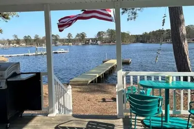 Steps from the water with a private dock, a big relaxing porch & great amenities
