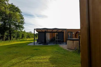 Image de This vacation home, with a private sauna and hot tub, has a cozy homey living room with an open kitchen, 2 bedrooms, and generous outdoor space.