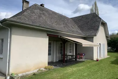 Image de Maison avec terrasse et jardin  au pied de la montagne.