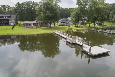 Image de Spacious grounds and home with large deck and dock in quiet cove.