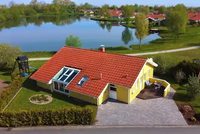 Image de 12 person family holiday home with sauna, whirlpool, two showers and toilets, wood-burning stove and canoe in 1st row to the lake with wonderful lake view in Otterndorf
