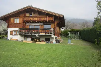 Image de magnifique chalet en madrier sur terrain arboré vue massif du Mont Blanc