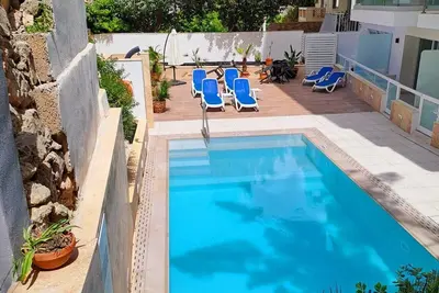 Image de Modern 2-bedroom apartment in central Mellieħa 🌞. Sleeps 6 with sofa bed, A/C, Wi-Fi, Smart Tv & lift access. Steps from shops, restaurants & public transport 🌴.