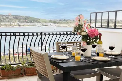 Image de Seafront apartment just steps from Mellieħa Bay, with stunning views of the bay and Red Tower. Enjoy spectacular sunsets, walk to nearby restaurants and amenities, and catch the bus right outside.