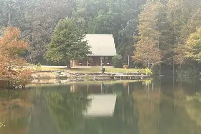 Image de Cozy Cabin setting behind a 1 1/2 acre pond that is lined with Cypress Trees.
