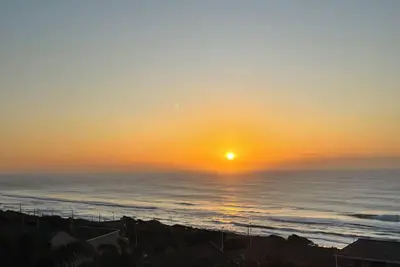 Image de Wake up to gorgeous sunrises and sea views upon a wooden balcony.