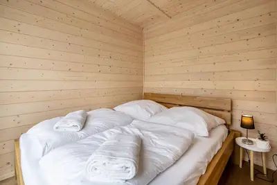 Image de Tiny House “Ditmar” avec vue directe sur le lac, terrasse, sauna et accès direct au lac