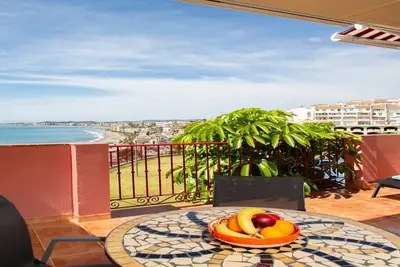 Image de This seaside apartment is perfect for relaxation with its terrace offering sea views and soothing wave sounds. It features two bedrooms, two fully equipped bathrooms, a spacious living room, and a kitchen. Enjoy meals or sunbathe on the loungers