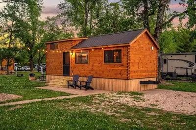 Image de Experience the timeless charm of the Pinecrest Cabin, a delightful twist on the classic cabin style. Step inside and be greeted by the warm and rustic log cabin ambiance that will transport you to the heart of Branson, Mo.