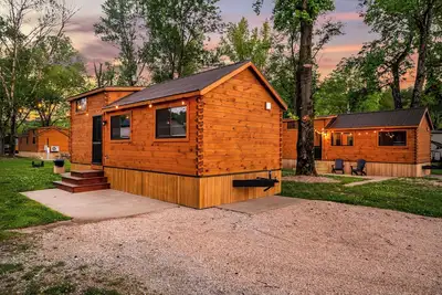 Image de Experience the timeless charm of the Pinecrest Cabin, a delightful twist on the classic cabin style. Step inside and be greeted by the warm and rustic log cabin ambiance that will transport you to the heart of Branson, Mo.