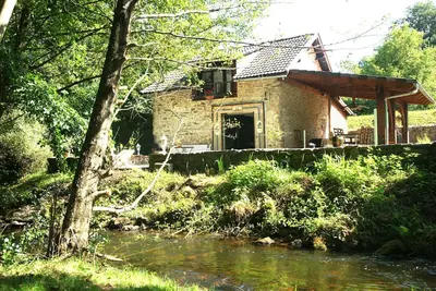Image de Moulin du Xii siècle dans un écrin de verdure.