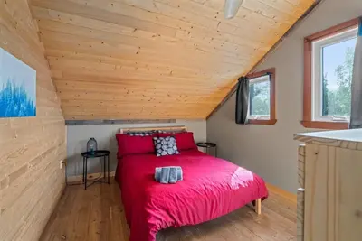 Image de Chalet en bois rond au bord de l'eau avec spa, foyer et table de pool.