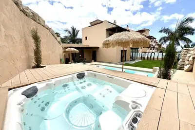 Image de Maison de luxe avec piscine, jacuzzi et vue sur la mer et le golf.