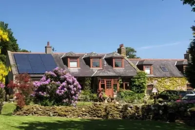 Image de Idyllic countryside haven with lush landscape, manicured garden, pond and stream