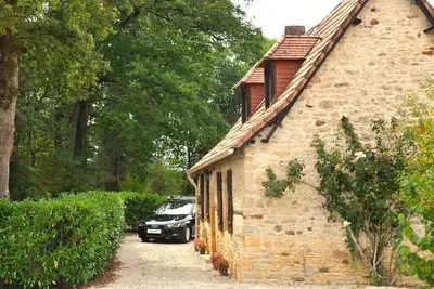 Image de Maison typique Lotoise noyée dans une verdure luxuriante avec piscine privative.