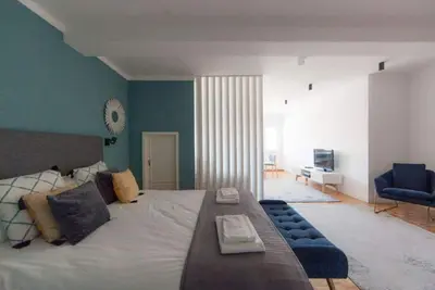 Image de Studio avec un lit double, un canapé-lit et l'air conditionné.