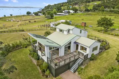 Image de Tikirau Bay Views - Tikirau Bay Views is a wonderfully appointed family holiday home right next to the beach in Oneroa. With three bedrooms (2 x singles and 2 x queens) and a good sized family bathroom, this is the perfect location for a family group