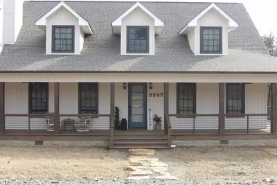 Image de Luxurious 5-bedroom lakefront house with 3 master bedrooms & a wrap-around porch