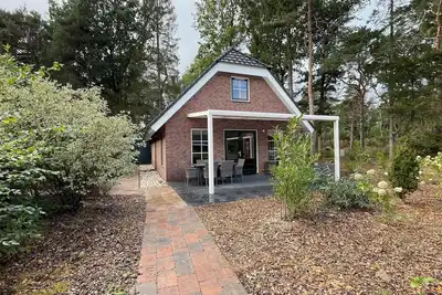 Image de Wellness bungalow with whirlpool, sauna, sunshower, 3 bedrooms, and a covered terrace with lounge set.