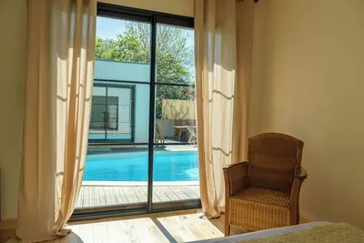 Image de Belle rénovation d'une longère avec extension moderne, donnant sur une piscine.