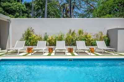 Image de Charming 4-bedroom home near beaches, with open floor plan, modern kitchen, and lush garden views.