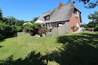 Image de Spacious half of the house under thatch with a beautiful garden. A dog on a question