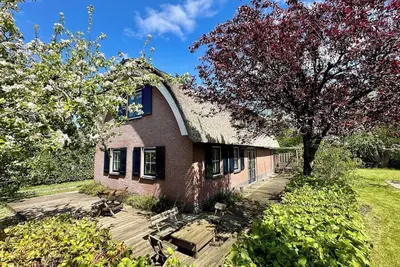 Image de A beautiful thatched vacation villa which is located within walking distance of 't Nije Hemelriek. On a beautiful spacious lot with many seats.