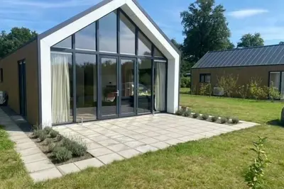 Image de This modern vacation home is the place to be. The house is suitable for four people, has two bedrooms and is completely on one level. Around the house is a spacious garden to relax in the sun.