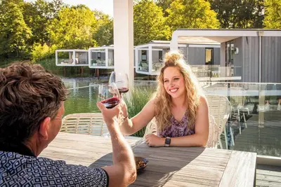 Image de Stylish water cube for 5 guests with modern interior walk in shower and large terrace floating above the water.