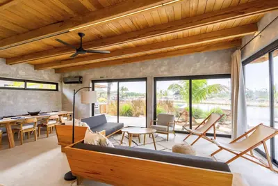 Image de Stylish waterfront villa with pool, lush views & floor-to-ceiling windows