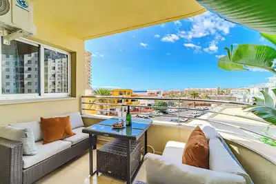 Image de Steps from the beach (≈500 m), this bright 2-bedroom boasts sweeping ocean views and a sunset-facing terrace. 100 Mbps Wi-Fi, A/C in both bedrooms and the living room, and a family-ready setup (crib on request) make it effortless for holidays