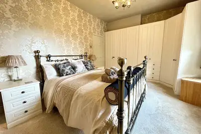 Image de Luxury 3‑bed apartment on Haworth’s famous Main Street. Light‑filled lounge with large, deep sofas, wood burner and 75\" smart Tv with Netflix, plus high‑end kitchen. Hotel‑quality beds and linen, parking, patio, bike store and dog friendly.