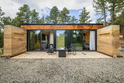 Image de Earth-Built Cabin with Pine Shadows and a Tub That Waits