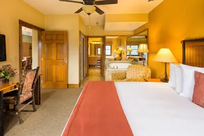 Image de Spacious 3-bedroom cabin — 2, 746 sq ft, sleeps up to 12 — full kitchen, in-unit washer/dryer and multiple living areas with balcony mountain views. Enjoy on-site Wild Bear Falls indoor water park, heated pools, award-winning spa, and dining.