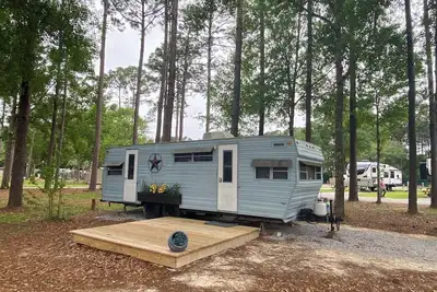 Image de The \"Bunkhouse\" (western-themed glamper) sleeps 2 to 4 avg size people. There's even a bar with real western saddles for barstools! All new electric appliances, so super-easy to \"glamp\" in a beautiful, treed area of the park. Access to the park's am