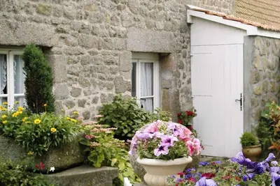 Image de maison de granit nichée au cœur d’un petit hameau entre terre et mer