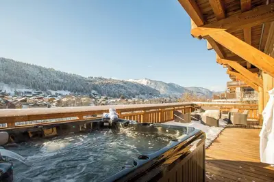Image de More Mountain – Chalet La Godille. Chalet de luxe avec grande terrasse et jacuzzi extérieur, réparti sur trois niveaux, situé à proximité immédiate de la télécabine de Super Morzine.