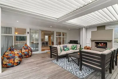 Image de All Decked Out - Modern holiday home with multiple decks including a covered outdoor entertaining space with open fireplace and plastic blinds. Close to shops, cafe, golf course, estuary and Mangawhai Activity Zone. Pet Friendly.