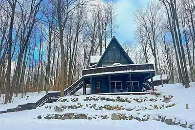 Image de 🔥 Cozy Bellaire A-Frame | Ski • Torch • Brew 🍻<br>Nestled in Schuss Mountain Resort—close to the slopes ⛷, Torch Lake 💙, and downtown Bellaire’s famous Short’s Brewery. Stay, play, and unwind by the fire pit under Northern Michigan skies 🌲✨